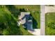 Aerial view showcases a home with deck, basketball hoop, manicured lawn, and a stone firepit at 7845 W Hillside Dr, Columbus, IN 47201