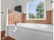 Bathroom featuring a luxurious soaking tub with tiled surround and picture window at 7845 W Hillside Dr, Columbus, IN 47201