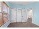 This bedroom has a triple-door closet and an open doorway to the hallway and staircase at 7845 W Hillside Dr, Columbus, IN 47201