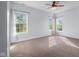 This bedroom has carpet, a ceiling fan, and two windows with natural light at 7845 W Hillside Dr, Columbus, IN 47201