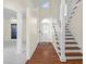 Bright foyer with hardwood floors, a staircase, and a front door with decorative glass at 7845 W Hillside Dr, Columbus, IN 47201