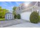 Attached two-car garage and storage shed with well-maintained driveway and landscaping at 7845 W Hillside Dr, Columbus, IN 47201