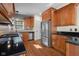 This kitchen features wooden cabinets, stainless steel appliances, black countertops, and hardwood floors at 7845 W Hillside Dr, Columbus, IN 47201