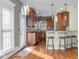 Well-lit kitchen with wood cabinets, bar seating, and hardwood floors with natural light at 7845 W Hillside Dr, Columbus, IN 47201
