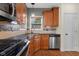 This kitchen features wooden cabinets, stainless steel appliances, tile backsplash, and hardwood floors at 7845 W Hillside Dr, Columbus, IN 47201