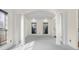 Bright living room with decorative columns, large windows, and neutral carpeting at 7845 W Hillside Dr, Columbus, IN 47201