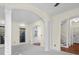 Bright living room with archways, decorative columns, neutral carpet, and adjacent staircase at 7845 W Hillside Dr, Columbus, IN 47201