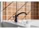 Close up of jetted tub with black fixtures and decorative tile surround at 7845 W Hillside Dr, Columbus, IN 47201