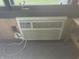 Window air conditioning unit on wall with electrical plug and side table at 805 Stewart Rd, Anderson, IN 46012
