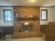 Basement fireplace with red brick surround, wooden mantel, and window views at 805 Stewart Rd, Anderson, IN 46012