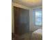 Bedroom features closet storage space and view of a red car through the window at 805 Stewart Rd, Anderson, IN 46012