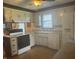Functional kitchen with white appliances, white cabinetry, and window view at 805 Stewart Rd, Anderson, IN 46012