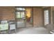 Outdoor patio space with chairs and view of brick exterior and sunroom through sliding glass doors at 805 Stewart Rd, Anderson, IN 46012
