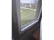A serene view of the neighborhood through a window with white trim at 805 Stewart Rd, Anderson, IN 46012