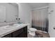 Well-lit bathroom with a toilet, vanity with sink, and shower with patterned curtain at 8153 Fivespot Ln, Plainfield, IN 46168