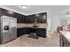 Well-lit kitchen features stainless steel appliances, stone countertops, and dark cabinetry at 8153 Fivespot Ln, Plainfield, IN 46168