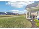 Backyard showcasing a covered patio with outdoor dining and grilling area, overlooking a serene water feature at 887 Tuxedo Dr, Westfield, IN 46074