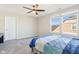 Bright bedroom with a ceiling fan, blue-striped bedspread, and large sunny windows at 887 Tuxedo Dr, Westfield, IN 46074