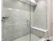 Modern shower stall with gray tiling, glass door, and built-in seating at 887 Tuxedo Dr, Westfield, IN 46074