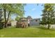 Back exterior view of home featuring a deck, well-maintained lawn, and mature trees at 9462 Bent Brook Dr, Indianapolis, IN 46250