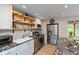 Well-equipped kitchen with stainless steel appliances, white cabinets, and open shelving at 9462 Bent Brook Dr, Indianapolis, IN 46250