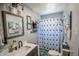 Bright bathroom featuring a modern vanity and sink, a framed mirror, and a shower with a patterned curtain at 97 N Maple St, Pittsboro, IN 46167