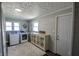 Organized laundry room with modern washer and dryer, white cabinets, and natural light from multiple windows at 97 N Maple St, Pittsboro, IN 46167