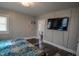 Relaxing bedroom with paneled walls, modern TV, and access to walk-in closet at 97 N Maple St, Pittsboro, IN 46167
