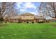 Charming brick home featuring a well-manicured lawn and mature trees at 10673 Rolling Springs Dr, Indianapolis, IN 46234
