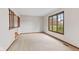 Spacious room with carpet, large window, wood trim, and staircase at 10673 Rolling Springs Dr, Indianapolis, IN 46234