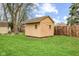 Well-maintained tan shed in backyard with trimmed lawn and privacy fence at 10673 Rolling Springs Dr, Indianapolis, IN 46234