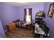 This purple bedroom features hardwood floors, with a bed, dresser, and a desk with multiple screens at 11403 Fairweather Pl, Indianapolis, IN 46229