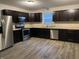 Well-lit kitchen featuring stainless steel appliances and dark cabinetry at 125 Hilltop Farms Blvd, Whiteland, IN 46184