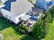 Bird's-eye view of a backyard featuring a stone patio with dining set, screened porch, and manicured lawn at 13875 Ambria Dr, McCordsville, IN 46055