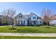 Beautiful two-story home boasts manicured front lawn and stone details and a blossoming tree at 13875 Ambria Dr, McCordsville, IN 46055