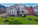 Charming two-story home featuring a manicured lawn and detailed brickwork and a front yard tree in full bloom at 13875 Ambria Dr, McCordsville, IN 46055