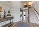 Inviting foyer featuring wainscoting, an antique table, and beautiful staircase leading to the second floor of the home at 13875 Ambria Dr, McCordsville, IN 46055
