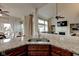 Granite countertop with stainless steel sink overlooking a living area with fireplace and large windows at 13875 Ambria Dr, McCordsville, IN 46055