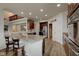 Open kitchen with granite counters, wood floors, a stainless steel refrigerator, and an attached breakfast bar at 13875 Ambria Dr, McCordsville, IN 46055