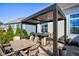Elegant outdoor patio featuring a covered dining area with built-in fire pit and sleek patio furniture at 13875 Ambria Dr, McCordsville, IN 46055