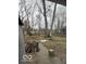 View of the backyard with a wooden deck, trees, and wet ground at 1536 W 74Th Pl, Indianapolis, IN 46260