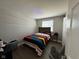 This bedroom has wood floors, a colorful bedspread, and a window with blinds at 1536 W 74Th Pl, Indianapolis, IN 46260