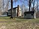 The backyard with mature trees, a storage shed, and a charming view of the home's exterior at 155 Boring Pl, Martinsville, IN 46151