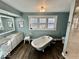 Bright bathroom with a vintage-style tub, white vanity, and charming decor at 155 Boring Pl, Martinsville, IN 46151