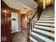 Inviting entryway features exposed brick, hardwood floors, and a classic staircase leading to the upper level at 155 Boring Pl, Martinsville, IN 46151