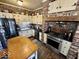 Country kitchen featuring brick accents, stainless steel appliances, and rustic wood island at 155 Boring Pl, Martinsville, IN 46151