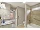 Bright bathroom featuring a granite countertop vanity and a tiled tub and shower at 1715 E Kelly St, Indianapolis, IN 46203