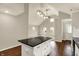 Kitchen with a black island, black countertops, wood floors and views of the living room at 1715 E Kelly St, Indianapolis, IN 46203