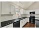 Bright kitchen features white cabinets, black countertops, and stainless steel appliances at 1715 E Kelly St, Indianapolis, IN 46203