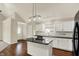 Kitchen features a modern island, white cabinets, black countertops, and stainless steel appliances at 1715 E Kelly St, Indianapolis, IN 46203